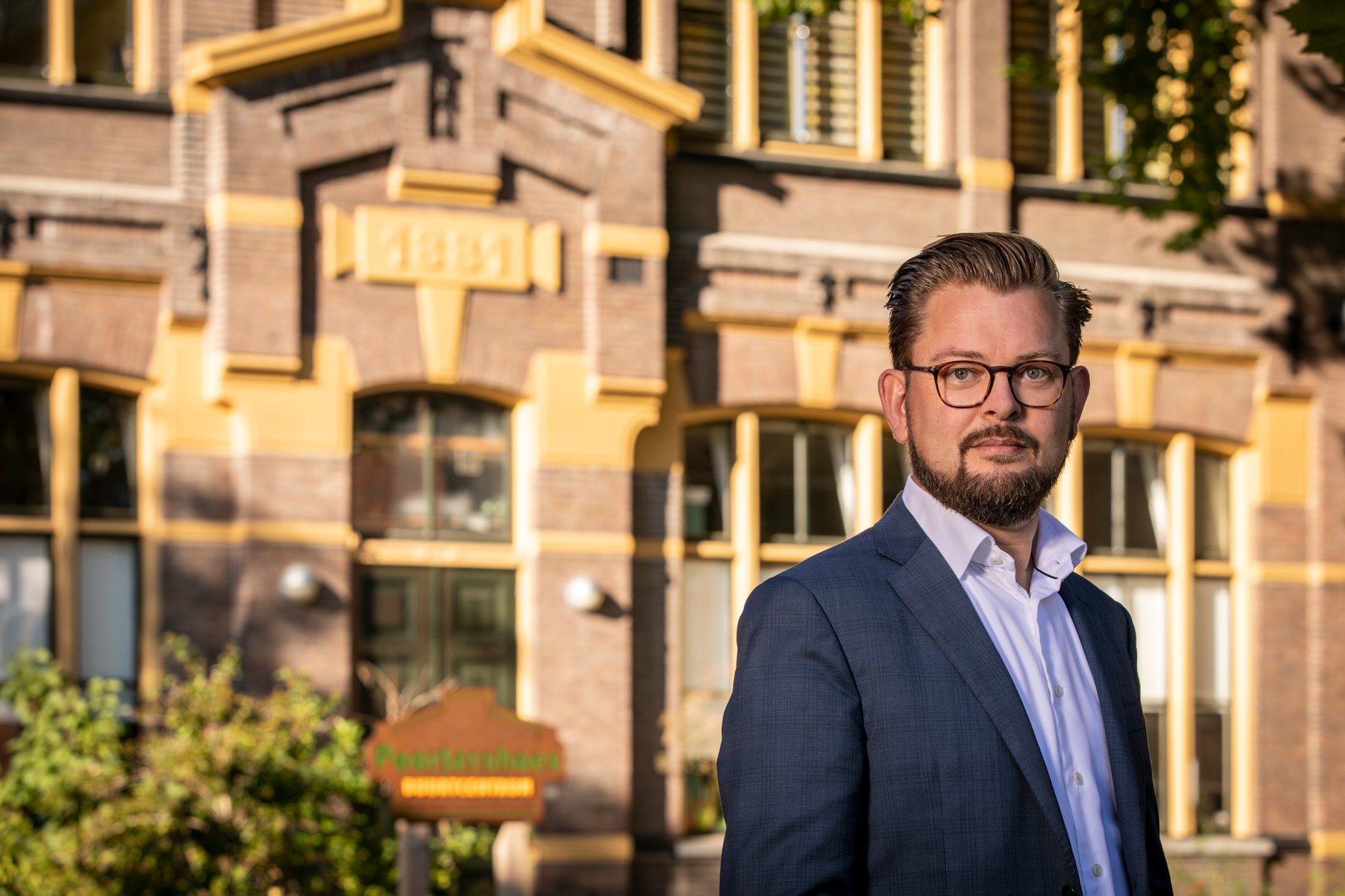 Wethouder Eelco Eikenaar voor een oud huis