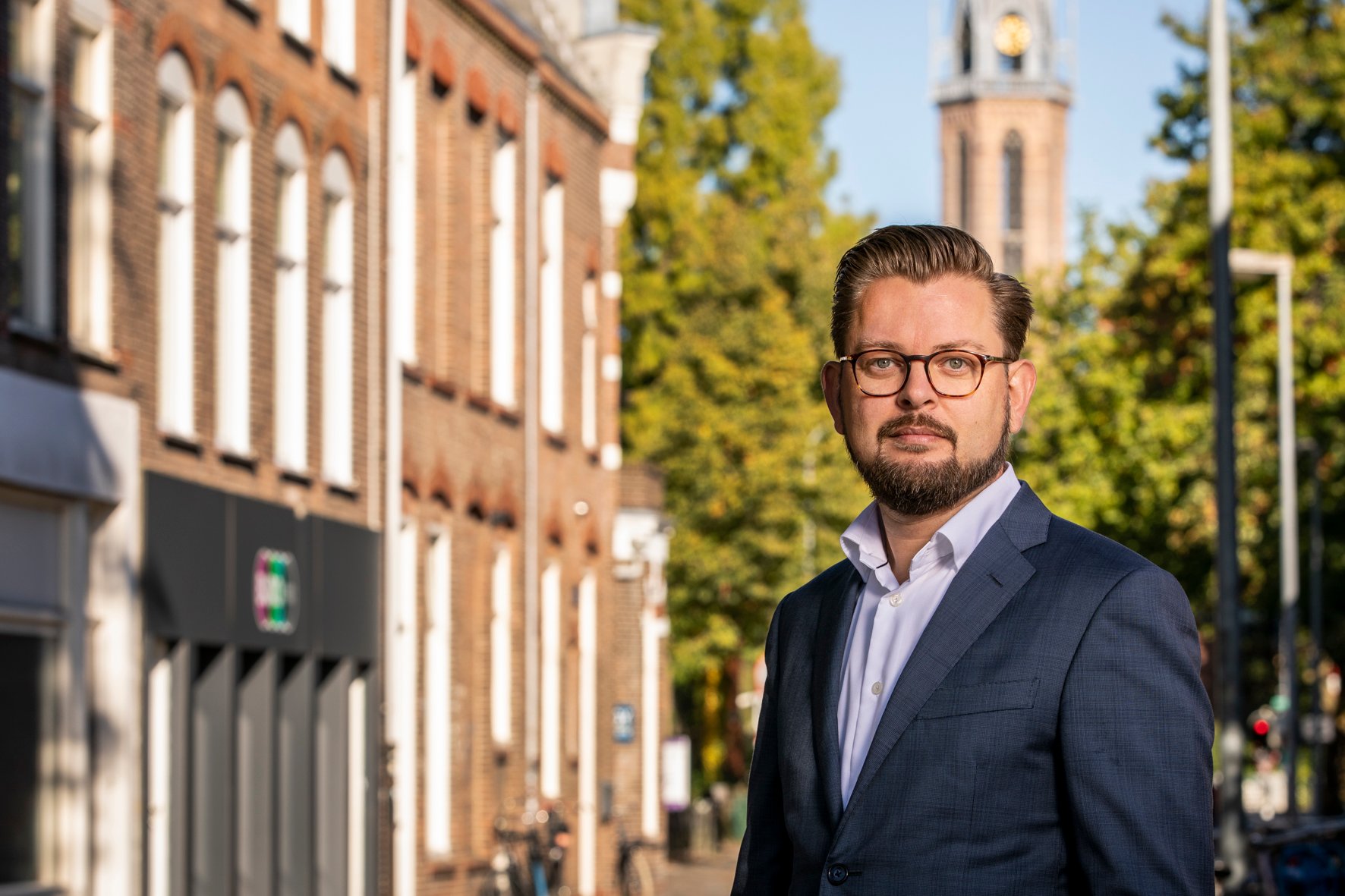 Portretfoto wethouder Eelco Eikenaar met een kerk op de achtergrond